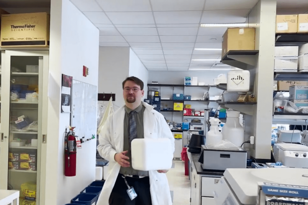 Aleksandar Obradovic, Ph.D. holding a white laboratory box